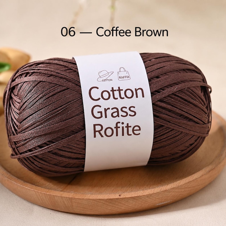 May include: A ball of coffee brown yarn wrapped in a white paper label with the text 06 - Coffee Brown and Cotton Grass Rofite. The label features small line art icons of a hat and a handbag, indicating the material is suitable for crafting.