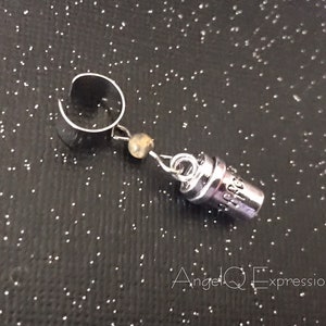 May include: Silver ear cuff with a small charm that says "Hope" hanging from it.