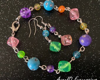 Può includere: Un braccialetto a catena d'argento con dadi e perline di vetro colorate. Orecchini abbinati con un gancio d'argento e dadi e perline di vetro colorate. Il braccialetto ha una chiusura d'argento.