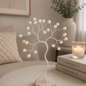 May include: A decorative wire tree sculpture featuring white pearl-like beads at the ends of its branches. The tree is mounted on a circular wooden base with the handwritten text "Happy 30th Anniversary!" inscribed on the top surface of the wood.