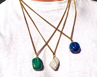 May include: Three gold chains with different colored stone pendants. The stones are wrapped in gold wire. The stones are green, white, and blue.