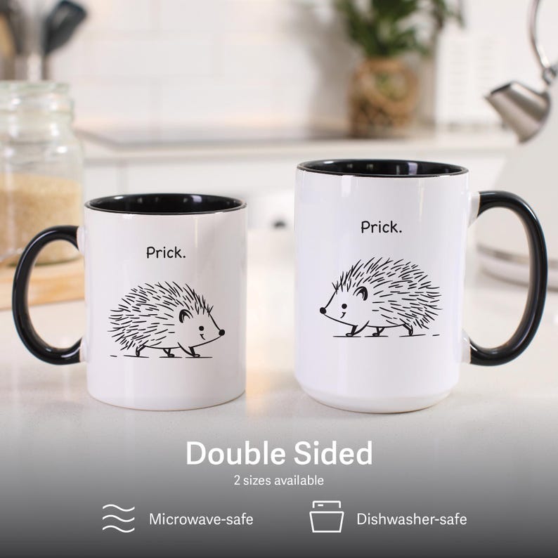 K&ouml;nnte beinhalten: Zwei wei&szlig;e Keramikbecher mit schwarzen Griffen und Innenr&auml;umen. Jeder Becher zeigt eine schwarze Strichzeichnung eines Igels und das Wort "Prick". Der Text "Double Sided" und "2 Gr&ouml;&szlig;en verf&uuml;gbar" stehen unter den Bechern. Die Becher sind mikrowellen- und sp&uuml;lmaschinenfest.