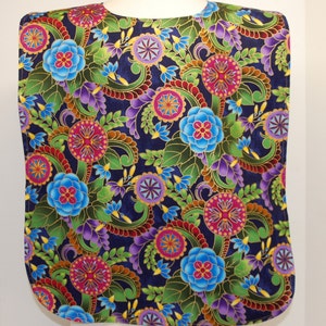 May include: A dark blue fabric bib with a colorful floral pattern. The pattern features blue, red, pink, green, purple, and gold flowers and swirls.