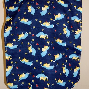 Puede incluir: Un babero azul con un patrón de ángeles amarillos que sostienen estrellas y corazones rojos. El babero tiene un escote redondeado y un borde inferior curvo.