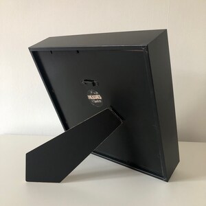 May include: Black picture frame with a black easel stand. The frame has a small sticker on the back that says "Treasured Times".