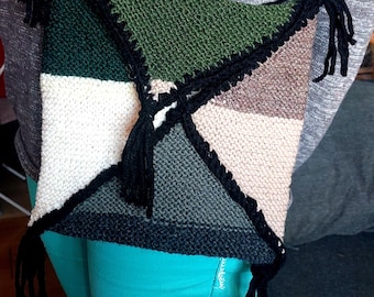 May include: A knitted crossbody bag with a geometric pattern in shades of green, brown, white, and black. The bag has black tassels and a black crocheted trim.
