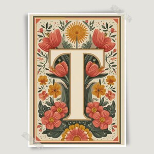 May include: A rectangular art print featuring a large, cream-coloured capital letter T centred within a decorative border. The design is surrounded by symmetrical illustrations of orange, red, and yellow flowers with green leaves on a cream background.