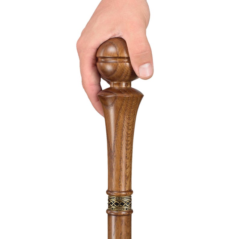 May include: A wooden walking stick with a brown, rounded handle and a decorative brass band. The stick is made of dark wood and has a smooth finish.