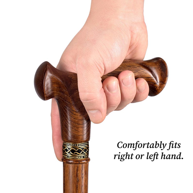K&ouml;nnte beinhalten: Gehstock aus dunkelbraunem Holz mit gebogenem Griff. Der Griff ist auf Komfort ausgelegt. Der Stock hat ein dekoratives Metallband in der N&auml;he der Oberseite und den Text "Comfortably fits right or left hand."