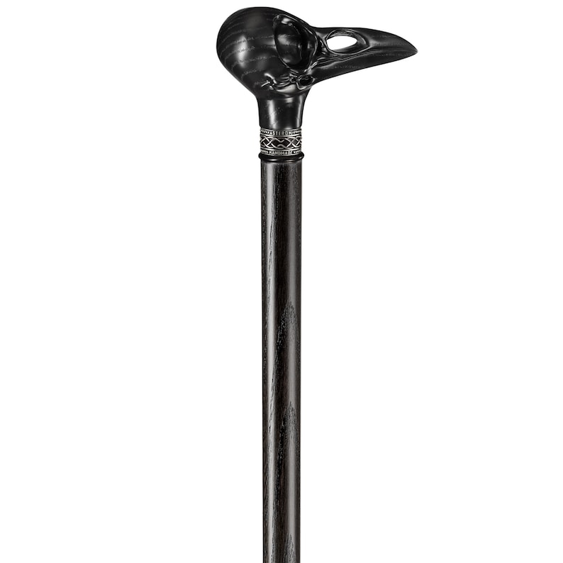 May include: A black walking stick with a carved raven skull handle. The handle has a silver band with a decorative design.