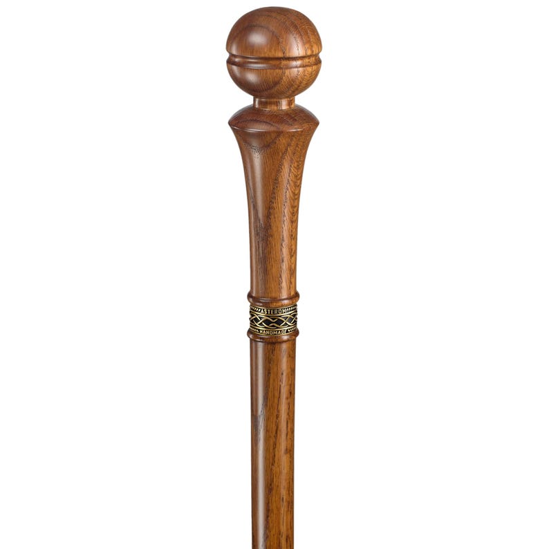 May include: A wooden walking stick with a rounded top and a decorative metal band. The stick is brown and has a natural wood grain.