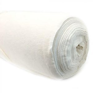 Può includere: Un rotolo di tessuto bianco, avvolto strettamente, con strati visibili. Il tessuto ha un aspetto morbido e strutturato, che suggerisce un materiale soffice. Il rotolo è posizionato su uno sfondo bianco, evidenziando il colore e la consistenza del tessuto.