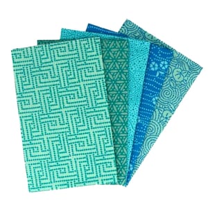 May include: A set of six fabric squares with different geometric patterns in shades of blue and green.