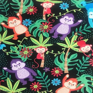 Könnte beinhalten: Stoffmuster mit orangefarbenen, lila und roten Cartoon-Affen auf schwarzem Hintergrund. Das Design umfasst grüne tropische Blätter, Palmen und bunte Blumen in Rot, Blau und Rosa.