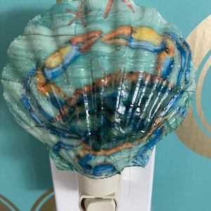 May include: A blue and yellow crab nightlight in a seashell with a starfish design.