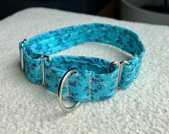 Puede incluir: Un collar para perro azul claro con un patrón floral y herrajes plateados.