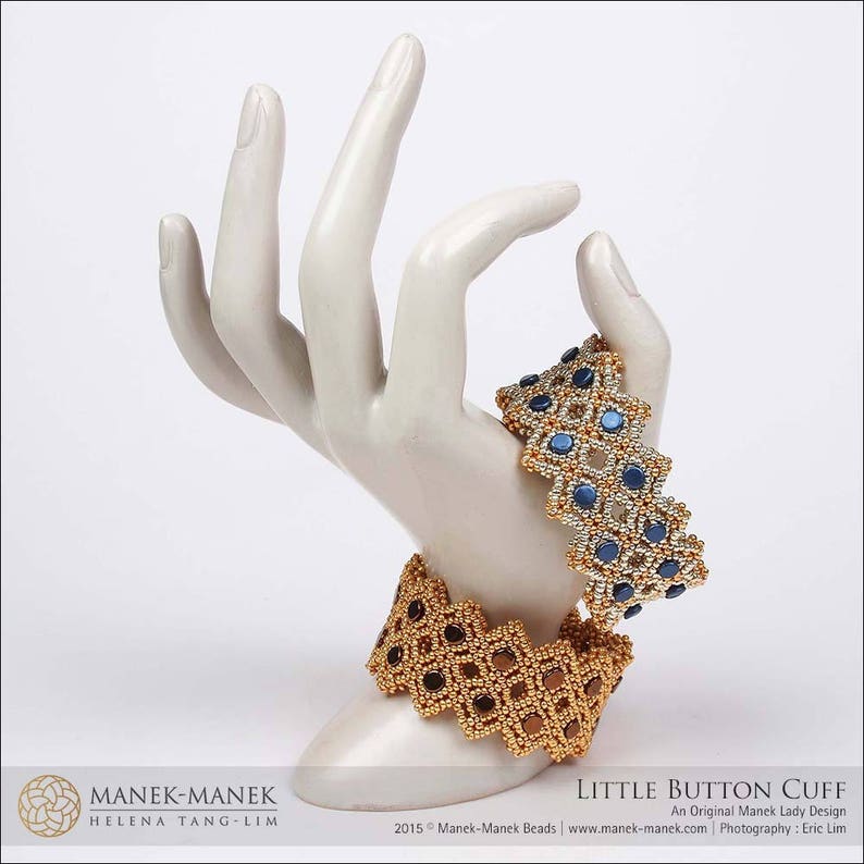 May include: Two beaded cuff bracelets, one gold and brown, the other gold and blue, displayed on a white ceramic hand. The bracelets have a geometric design. The text "LITTLE BUTTON CUFF" is visible.