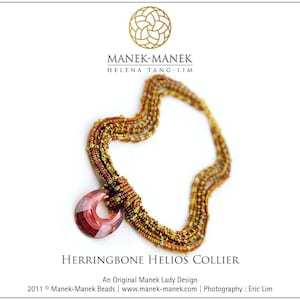 Op de afbeelding: Een meerstrengs ketting gemaakt van kleine gouden en bruine kralen met een grote, donkerrode, gefacetteerde hanger. De ketting heet "Herringbone Helios Collier" en is een origineel ontwerp van Manek-Manek Beads.
