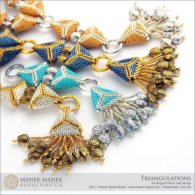 Op de afbeelding: Een close-up van een kralenketting met driehoekige hangers in tinten goud, turquoise en blauw. De ketting heeft een kwast met gouden en zilveren kralen.