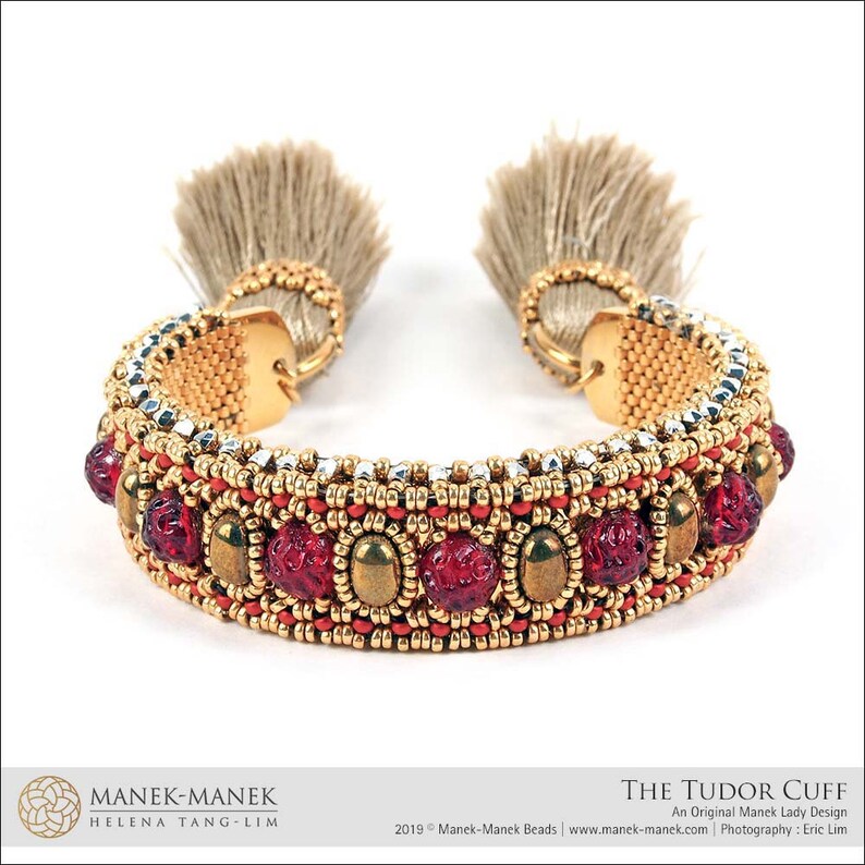 Peut inclure: Un bracelet en perles dor&eacute;es et argent&eacute;es avec des perles de verre rouges et des glands. Le bracelet s'appelle "The Tudor Cuff" et est un design original de Manek Lady.