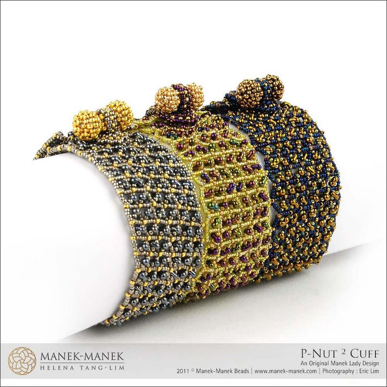 May include: Three beaded bracelets in different colors, including black, gold, and purple. The bracelets are made with small beads and have a woven pattern. The bracelets are stacked on top of each other, with the black bracelet on the bottom, the gold bracelet in the middle, and the purple bracelet on top. The bracelets are labeled "P-NUT 2 CUFF" and "An Original Manek Lady Design".