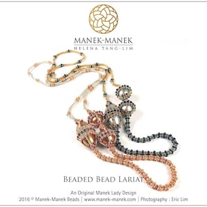 May include: Three beaded necklaces with gold, silver, and black beads. The necklaces are arranged in a layered fashion, with the gold necklace on top, the silver necklace in the middle, and the black necklace on the bottom. The necklaces are all adorned with decorative beads, including some that are shaped like teardrops. The necklaces are called "Beaded Bead Lariat" and are an original Manek Lady Design.