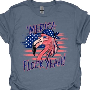 Könnte beinhalten: Ein blaues T-Shirt mit einem rosa Flamingo, der eine Sonnenbrille und ein Bandana mit Sternen und Streifen trägt. Der Flamingo steht vor einer amerikanischen Flagge mit dem Text 'Merica Flock Yeah!'