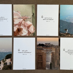 Puede incluir: Una colecci&oacute;n de ocho postales rectangulares con varios dise&ntilde;os. Algunas tarjetas presentan fotograf&iacute;as florales o de paisajes, mientras que otras tienen un patr&oacute;n de cuadr&iacute;cula y caligraf&iacute;a &aacute;rabe con traducciones al ingl&eacute;s. Las tarjetas est&aacute;n dispuestas sobre una superficie marr&oacute;n.