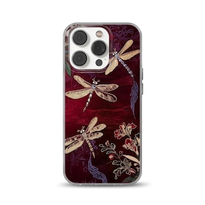 May include: A clear phone case with a burgundy background and gold dragonfly designs. The case has a cutout for the camera lens.