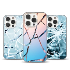 May include: Three phone cases with a cracked glass design. The cases feature a clear protective shell and a graphic of shattered glass in shades of blue, white, and a gradient of pink and blue. The phone cases have a camera cutout.