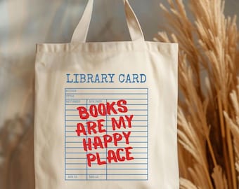 May include: Cream-colored tote bag with the text "LIBRARY CARD" in blue at the top. Below, a library card design with the words "BOOKS ARE MY HAPPY PLACE" in red. The bag has two handles.