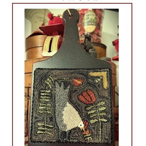 May include: A hand-punched piece featuring a chicken design, measuring 6.5" x 6". The artwork includes a black handle and a detailed image of a chicken, flowers, and foliage. The text reads "Funky Henrietta Chicken Punch Needle".