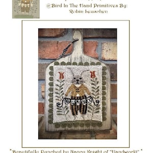 May include: A punch needle pattern featuring a bunny wearing a brown jacket and holding a banner that says "Funny". The pattern is framed on a wooden board with a rustic finish. The finished piece measures 5 1/2 inches by 7 1/2 inches.
