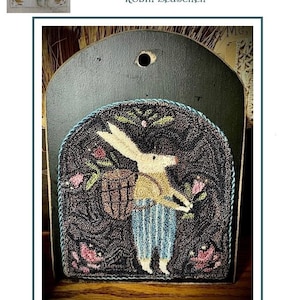 Puede incluir: Un tapiz de pared perforado a mano que representa un conejo recogiendo tulipanes, con el texto "Gathering Tulips Rabbit". La obra de arte está enmarcada en un soporte de madera oscura. La pieza terminada mide 14 cm x 13,3 cm.