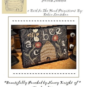 May include: A punch needle pattern for a beehive pillow with the text "A Bee C Beeskep" and "e Bird In The Hard Primitives By: Robin Leuscher". The finished pillow is 5 inches by 6 1/2 inches.