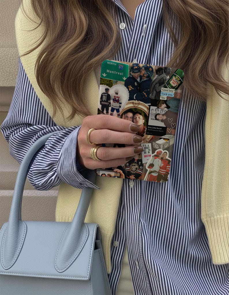 K&ouml;nnte beinhalten: Eine hellblaue Handtasche mit gebogenem Griff wird in der N&auml;he eines gestreiften blau-wei&szlig;en Hemdes gehalten. Eine Handyh&uuml;lle mit einer Collage von Bildern, darunter Eishockeyspieler und Text, wird vor dem Hemd gehalten. Goldringe schm&uuml;cken die Finger.