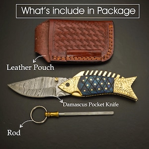 May include: A Damascus pocket knife with a fish-shaped handle, a leather pouch, and a rod. The knife blade has a unique pattern. The fish handle is gold and blue. The leather pouch is brown.