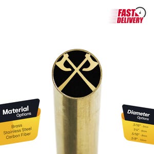 May include: A brass pen blank with a black background and a gold design of two crossed axes. The blank is available in brass, stainless steel, or carbon fiber. The diameter options are 3/16 inch (5 mm), 1/4 inch (6 mm), 5/16 inch (8 mm), and 3/8 inch (10 mm).
