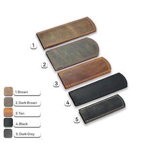 Peut inclure: Cinq étuis en cuir de différentes couleurs : marron, marron foncé, beige, noir et gris foncé. Chaque étui a une extrémité arrondie et des coutures sur les bords. Les couleurs sont numérotées.