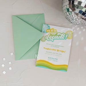 May include: A green envelope with a white invitation card inside. The invitation card has a colorful design with the text "on to a new decade!" and details about a slumber party to celebrate Teagan's 10th birthday. The party is on Saturday, July 13th, 2024, with a drop off time of 3pm and a pick up time of 10am. The invitation also includes the location, "The Bowman House".