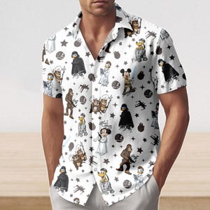 May include: White short-sleeved shirt with a Star Wars and Disney character print. The shirt features a repeating pattern of Darth Vader, Mickey Mouse, Donald Duck, and other characters, along with stars and space-themed elements.