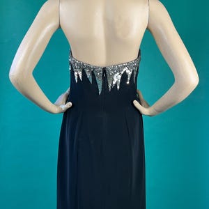 May include: A black strapless dress with a silver sequined bodice. The sequins are arranged in a cascading pattern.