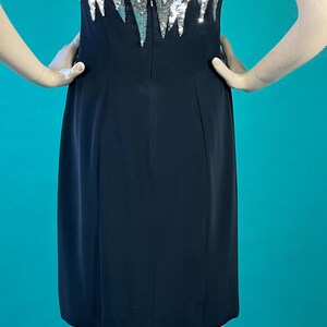 May include: A black strapless dress with a silver sequined bodice. The sequins are arranged in a cascading pattern.