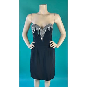May include: A black strapless dress with a silver sequined bodice. The sequins are arranged in a cascading pattern.