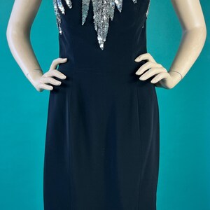May include: A black strapless dress with a silver sequined bodice. The sequins are arranged in a cascading pattern.