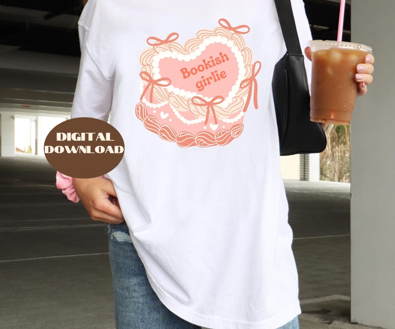 May include: White long-sleeve t-shirt with a pink heart-shaped graphic that says "Bookish girlie".