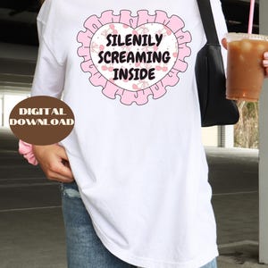 K&ouml;nnte beinhalten: Wei&szlig;es Langarm-T-Shirt mit einer pinkfarbenen Grafik eines Herzens mit Kirschen und dem Text "Silently Screaming Inside".