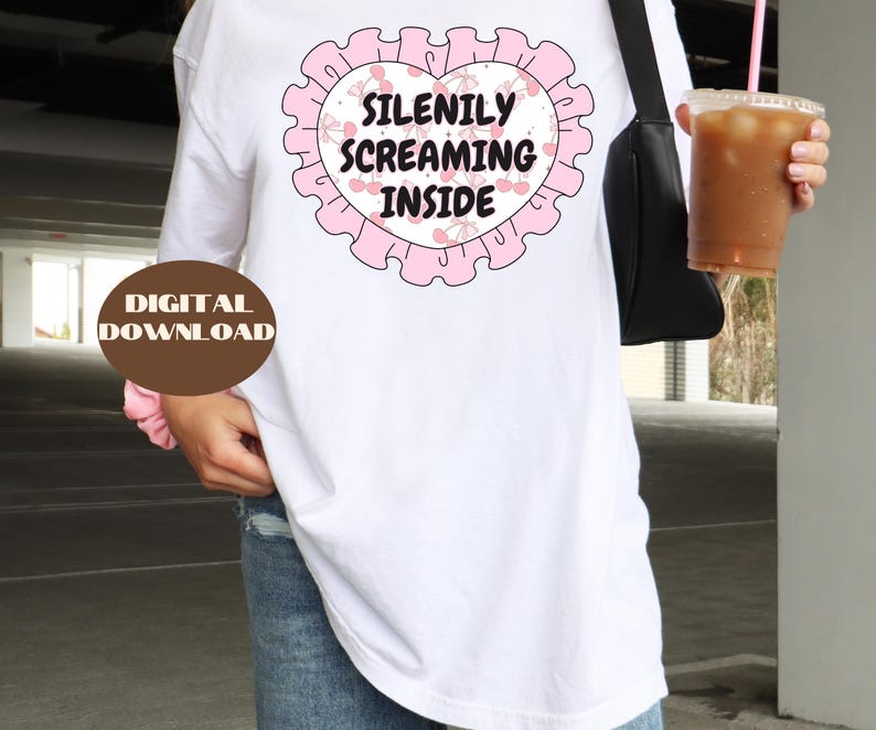 K&ouml;nnte beinhalten: Wei&szlig;es Langarm-T-Shirt mit einer pinkfarbenen Grafik eines Herzens mit Kirschen und dem Text "Silently Screaming Inside".