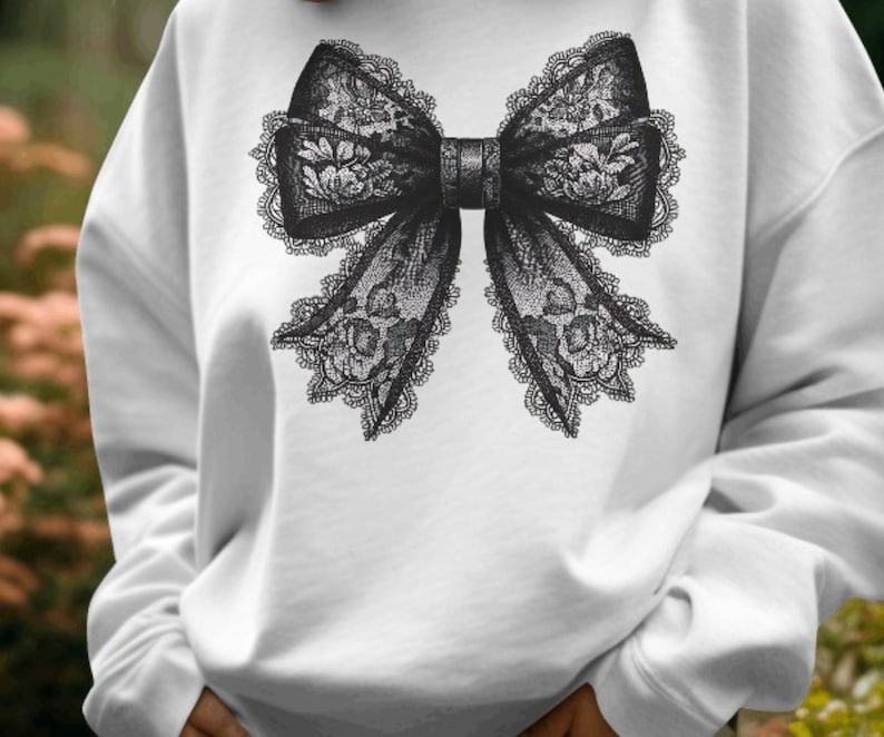 May include: White sweatshirt with a black lace bow design.