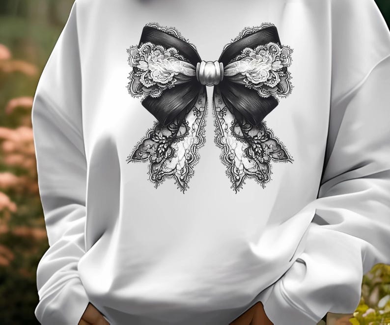 May include: White sweatshirt featuring a black and white lace bow design.